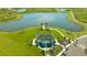 Beautiful aerial view of a community clubhouse overlooking a pond with lush green landscaping and a walking path at 8545 Daybreak St, Sarasota, FL 34241