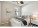 Cozy bedroom with a ceiling fan, window, and nightstand with lamp at 13864 Posada St, Venice, FL 34293