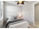Cozy bedroom with a ceiling fan, window, and nightstand with lamp and a door leading to another room or bathroom at 13864 Posada St, Venice, FL 34293