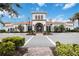 Elegant clubhouse featuring a tile roof, arched entryway, and meticulously maintained landscaping at 13864 Posada St, Venice, FL 34293