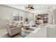 Bright, open living room featuring neutral furniture and decor, leading to the dining area and kitchen at 13864 Posada St, Venice, FL 34293