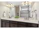 Bright main bathroom with double sinks, granite countertops, dark cabinetry, and a large mirror at 13864 Posada St, Venice, FL 34293