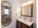 Bathroom with wooden mirror frames, white vanity and walk-in shower with patterned tile at 1423 Avenida Del Circo # 1C, Venice, FL 34285