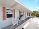 Charming condo featuring a cozy seating area with stylish wooden chairs and coral-colored shutters, inviting relaxation at 1423 Avenida Del Circo # 1C, Venice, FL 34285