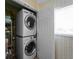 Stacked washer and dryer in laundry room with ample shelf space at 1423 Avenida Del Circo # 1C, Venice, FL 34285