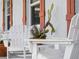 Up-close view of white wooden Adirondack chairs, with a small white table with succulents on a textured patio at 1423 Avenida Del Circo # 1C, Venice, FL 34285
