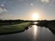 Scenic golf course with a pond reflecting the sunrise, showcasing lush greens and serene landscapes at 256 Royal Oak Way, Venice, FL 34292
