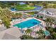 Aerial view of a sparkling swimming pool with lounge chairs, umbrellas, palm trees, and a nearby golf course at 256 Royal Oak Way, Venice, FL 34292