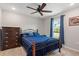 Cozy bedroom with a metal frame bed, blue bedding, and matching curtains, plus a wood dresser at 2949 Jaylene Rd, North Port, FL 34288