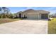Well-maintained single-story home with a large driveway, a two-car garage, and tidy landscaping at 2949 Jaylene Rd, North Port, FL 34288
