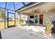 The screened patio area features a ceiling fan, comfortable seating, a view of the backyard, and a TV at 2949 Jaylene Rd, North Port, FL 34288