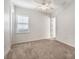 Neutral bedroom with carpet and patterned wallpaper, complemented by a ceiling fan and a window at 400 Maraviya Blvd, Nokomis, FL 34275