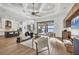 Open-concept living area with stylish furniture, coffered ceilings, and views of the pool area, great for entertaining at 400 Maraviya Blvd, Nokomis, FL 34275