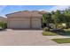 Charming single-story home featuring a tile roof, attached two-car garage, and a beautifully landscaped front yard at 438 Grand Preserve Cv, Bradenton, FL 34212