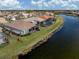 Waterfront homes with screened lanais line a tranquil canal under a partly cloudy sky at 651 Lakescene Dr, Venice, FL 34293