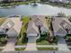 Aerial view of home and lush landscaped yard, with a lake in the background at 651 Lakescene Dr, Venice, FL 34293