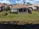 Backyard view with screened-in lanai overlooking a tranquil lake and lush landscaping at 651 Lakescene Dr, Venice, FL 34293
