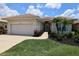Charming single-story home with manicured lawn, lush landscaping, and a well-maintained tile roof at 651 Lakescene Dr, Venice, FL 34293