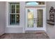 Elegant front door with decorative glass, sidelight window, and tiled entryway at 651 Lakescene Dr, Venice, FL 34293