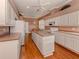 Well-lit kitchen with hardwood floors, ample counter space, island, and modern appliances at 651 Lakescene Dr, Venice, FL 34293
