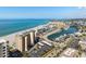 An aerial shot featuring condominiums, beachfront, a bay, and tropical landscape, all under a clear blue sky at 840 The Esplanade N # 104, Venice, FL 34285