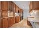 Well-lit kitchen with wooden cabinets, quartz countertops, tiled floors, and modern black stainless steel appliances at 840 The Esplanade N # 104, Venice, FL 34285