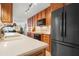 Contemporary kitchen featuring light countertops, wooden cabinets, and black stainless-steel appliances, with an ocean view at 840 The Esplanade N # 104, Venice, FL 34285