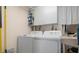 Functional laundry area equipped with a washer, dryer, storage cabinets, and cleaning supplies at 840 The Esplanade N # 104, Venice, FL 34285