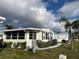 Serene view of the property with lush landscaping, a palm tree, and close proximity to the water at 863 Baveno Dr, Venice, FL 34285