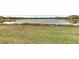 Expansive backyard with well-manicured lawn and a serene view of the pond at 9895 Wingood Dr, Venice, FL 34292