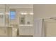 Bright bathroom featuring a glass enclosed shower, soaking tub, and vanity with double sinks at 9895 Wingood Dr, Venice, FL 34292