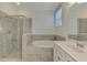Bright primary bathroom featuring a glass enclosed shower, soaking tub and neutral tile at 9895 Wingood Dr, Venice, FL 34292