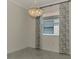 Bright dining room with tiled floors, large window, and decorative chandelier at 9895 Wingood Dr, Venice, FL 34292