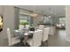 Dining room with decoratively set table and kitchen featuring granite countertops in background at 9895 Wingood Dr, Venice, FL 34292