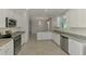 Spacious kitchen featuring stainless steel appliances, granite countertops, and tiled floors at 9895 Wingood Dr, Venice, FL 34292