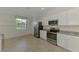 Bright kitchen featuring stainless steel appliances, granite countertops, and tiled floors at 9895 Wingood Dr, Venice, FL 34292
