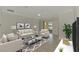 Bright living room with neutral decor, modern furnishings, and a sliding glass door leading to a scenic outdoor space at 9895 Wingood Dr, Venice, FL 34292