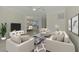Bright living room with neutral decor, modern furnishings, and a sliding glass door leading to a scenic outdoor space at 9895 Wingood Dr, Venice, FL 34292