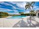 Stunning community pool with tropical landscaping and plenty of lounge chairs for relaxation at 9895 Wingood Dr, Venice, FL 34292