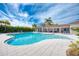 Resort-style pool with spacious deck, comfortable seating, and lush tropical landscaping at 9895 Wingood Dr, Venice, FL 34292