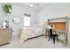Well-lit bedroom featuring a modern desk, dresser and a comfortable bed at 107 Corte Del Rosa, Venice, FL 34285