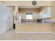 A kitchenette with white cabinets, granite countertops, and a breakfast bar at 107 Corte Del Rosa, Venice, FL 34285