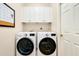 Functional laundry room with updated appliances and storage cabinets at 107 Corte Del Rosa, Venice, FL 34285