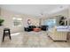 Open living room with neutral tile flooring, fan, and sliding doors to the lanai at 107 Corte Del Rosa, Venice, FL 34285