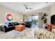 Bright living room featuring neutral tile flooring and sliding doors to the lanai at 107 Corte Del Rosa, Venice, FL 34285