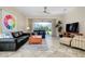Open living room with neutral tile flooring, fan, and sliding doors to the lanai at 107 Corte Del Rosa, Venice, FL 34285