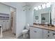 Well-lit bathroom with white cabinetry, granite countertop, and a separate shower room at 11053 Barnsley Dr, Venice, FL 34293