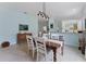 Bright dining room featuring wood table, neutral color palette, tile flooring, and bar access to the kitchen at 11053 Barnsley Dr, Venice, FL 34293