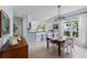 Bright dining room featuring wood table, neutral color palette, tile flooring, and bar access to the kitchen at 11053 Barnsley Dr, Venice, FL 34293