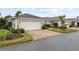 Attractive home featuring a paved driveway, two-car garage, and lush landscaping at 11053 Barnsley Dr, Venice, FL 34293